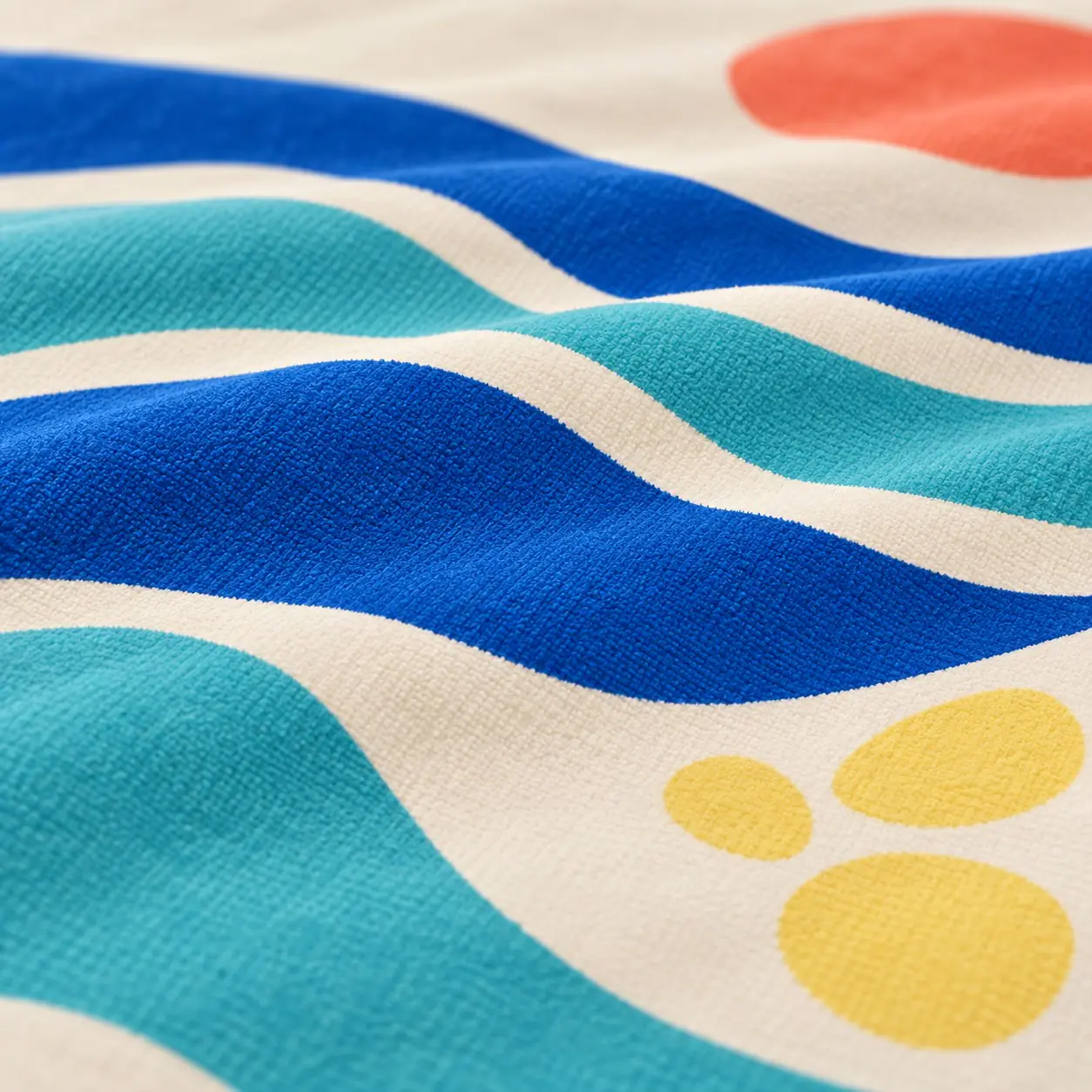 Close-up of microfiber beach towel showing blue wave print and soft fabric folds