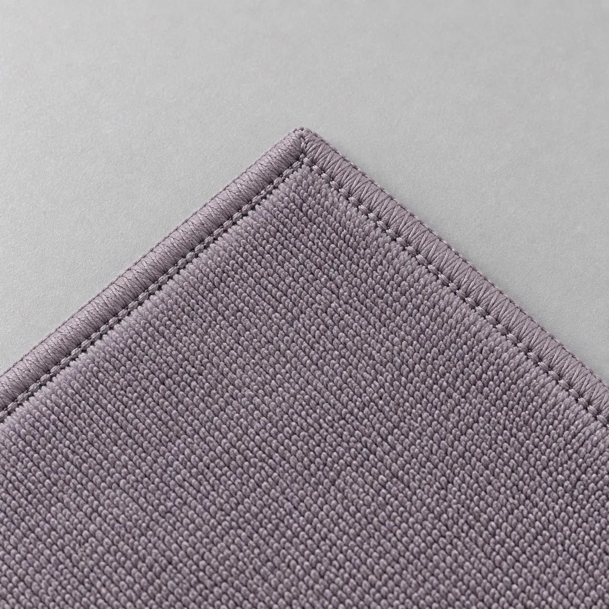Close-up of gray microfiber cleaning cloth corner and stitched hem